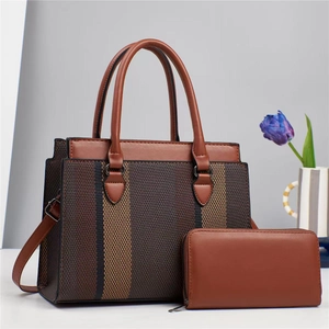 Brown textured leather handbag and wallet set displayed with a blue tulip in a modern setting