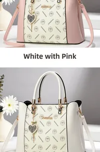 Détail du sac à main en cuir contrasté avec logo doré et pendentif cœur élégant