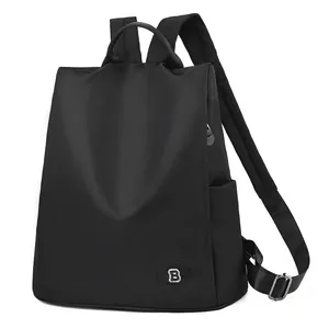 Sac à dos noir pour femme avec emblème 'B' et bretelles réglables sur fond blanc