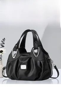 Détail de la texture plissée noire élégante et des ferrures métalliques du grand sac