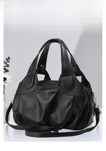Détail d'un sac nuage en cuir souple noir avec bandoulière amovible et finitions métalliques
