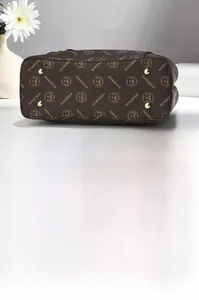 Détails du fond du sac avec rivets dorés de protection et motifs de monogrammes chics