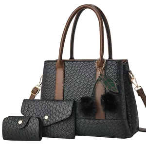 Set di borse tote nere intrecciate con manici in pelle marrone e ciondolo a pompon