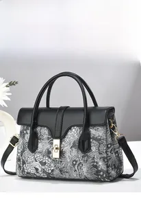 Detail of elegant black and white jacquard bucket bag with golden twist lock closure