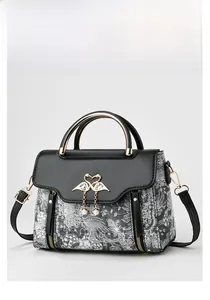 Detail of elegant black and white jacquard fabric bag with golden swan closure