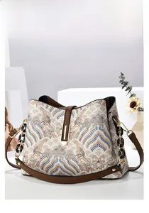 Détail du sac à main à motif jacquard avec bordure en cuir marron et bandoulière