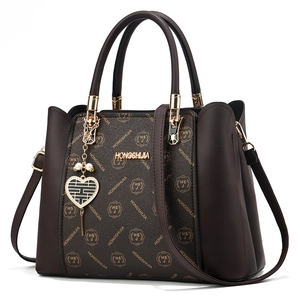 Sac à main marron classique avec monogramme, pendentif cœur doré et bandoulière