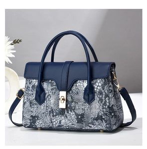 Close-up of vintage bucket bag with navy blue leather and jacquard floral texture