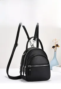 Detail view of black litchi pattern PU leather backpack with silver metal zippers and multi-layers