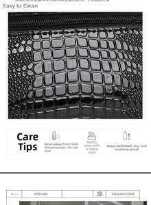Close-up of black crocodile embossed patent leather bag with gold zipper and care guide