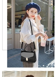 Close-up of a black croc-effect flap bag with golden twist lock for women's street style