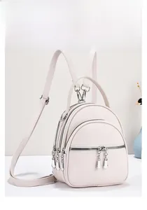 White pebbled leather mini backpack with three-layer zipper pockets and silver charms