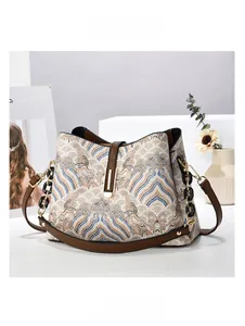 Détail du sac à main tissé avec motif ethnique bleu et marron et bandoulière chaîne