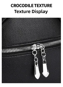 Detail shot of the black crocodile texture leather and dual silver metal zippers on bag