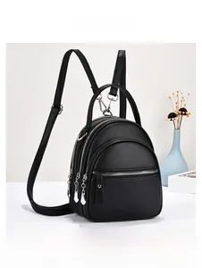 Detail view of black pebble leather backpack with three zipper layers and silver hardware
