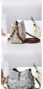 Détail du sac seau brodé avec motifs tissés et bandoulière en cuir de haute qualité