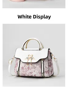 Detail view of jacquard handbag with swan diamond clasp and elegant pearl pendant