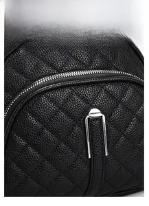 Detail of black quilted leather texture with crocodile pattern and silver metal zipper