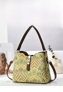 Detail of vintage bucket bag featuring yellow jacquard pattern and brown leather trim