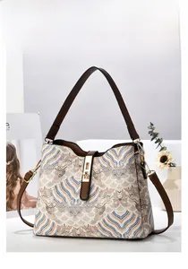 Detail of vintage wave pattern fabric bucket bag with leather strap and gold rotary lock
