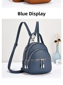 Detailed view of blue pebbled leather mini backpack with multiple silver zipper pockets