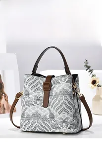 Dettaglio del ricamo e dei componenti metallici dorati di questa borsa a secchiello