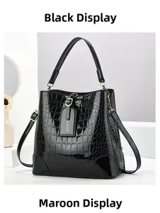 Detail of black crocodile pattern bucket bag with polished finish and branding tag