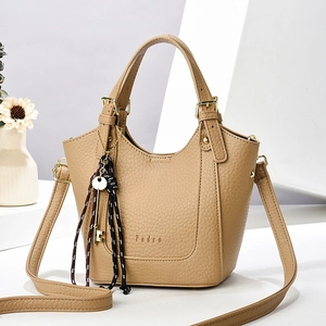 Sac fourre-tout en cuir marron avec poignées, bandoulière et pendentif tressé décoratif