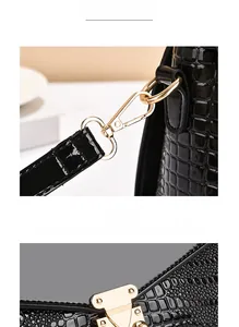 Detail of black crocodile pattern leather with shiny gold lobster clasp and metal lock