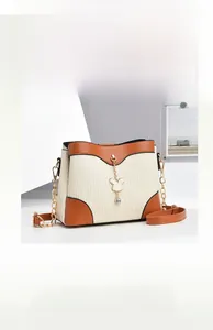 Detail of off-white pleated bucket bag with brown leather trim and golden rabbit charm