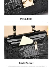 Close-up of golden metal twist lock and rear zipper pocket on black crocodile pattern bag