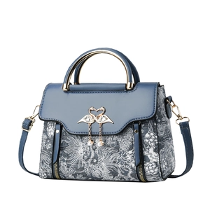 Elegant blue handbag with floral texture, golden bird clasp and pearl ornament detail