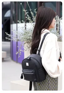 Vue extérieure d'un sac à dos noir à texture tressée avec poignée et fermeture antivol