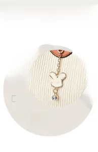 Detail of bunny-shaped hardware charm with sparkling crystal on pleated bucket bag
