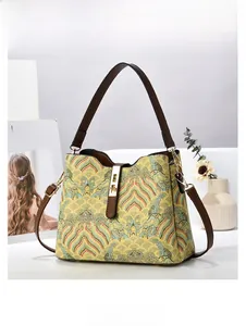 Detail of yellow bucket bag with traditional jacquard patterns and leather strap