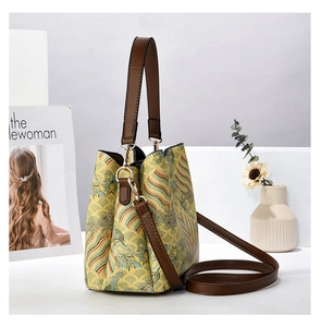 Detail of vintage bucket bag with Chinese embroidery and brown leather handle