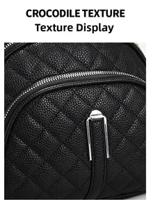 Détail de la texture crocodile noire et fermeture éclair argentée sur sac matelassé