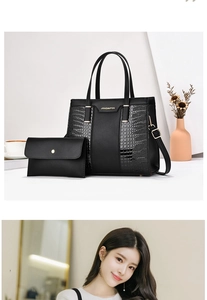 Macro detail of black leather tote with crocodile pattern拼接 and gold metal hardware
