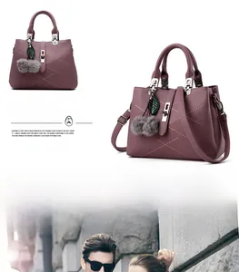 Purple lychee leather handbag featuring leaf charm, fuzzy ball and metallic lock detail