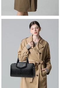 Détail d'un sac à main noir en similicuir crocodile avec motif en Y et doubles poignées