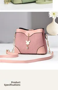 Close-up of pink pleated bucket bag with gold chain and cute rabbit gem pendant