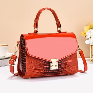 Orange glossy faux leather tote bag with crocodile pattern, gold buckle and shoulder strap