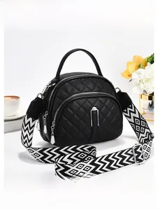 Détail du sac bandoulière matelassé noir avec large sangle à motifs géométriques