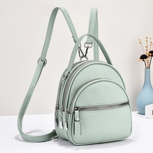 Mint green soft faux leather mini backpack with multiple zipper compartments and silver hardware