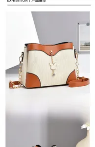 Detail of contrast stitch shoulder bag featuring brown leather trim and bunny charm