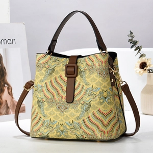 Elegante borsa ricamata gialla con motivi a nuvola tradizionali e pelle marrone