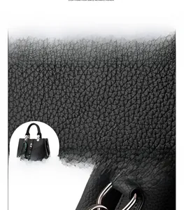Detail of premium black PU leather texture with decorative stitching and gray fur ball charm