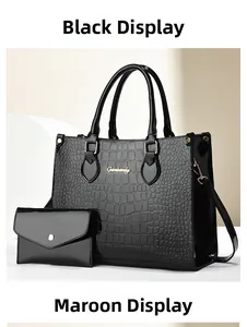Detail of glossy black crocodile pattern tote bag set with golden hardware and handles
