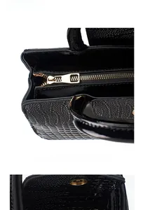 Détails du sac noir brillant motif crocodile avec fermeture éclair dorée et bouton magnétique