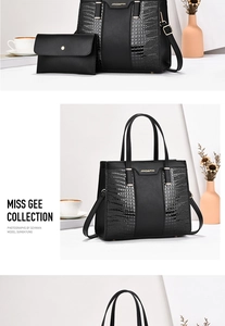 Detail view of black crocodile pattern tote bag set with matching small clutch and logo